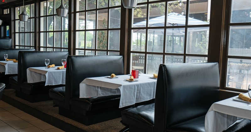 Restaurant interior with black leather booths and large windows