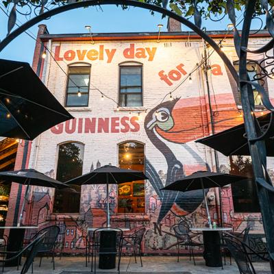 Restaurant outdoor seating area, colorful mural on the wall.