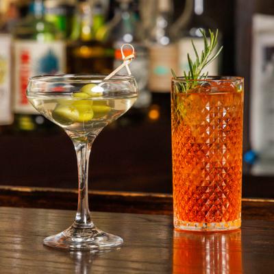 Two cocktails with olives and rosemary.