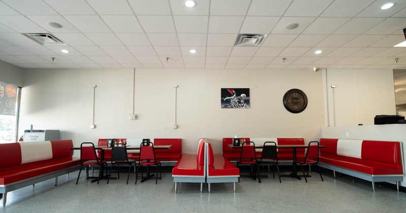 Interior, open space dining area, padded benches with tables and chairs