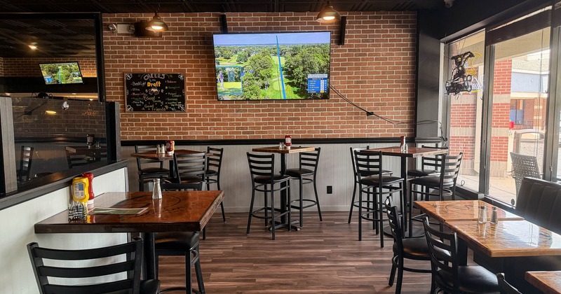 Interior, chairs, tables and big TV on the wall