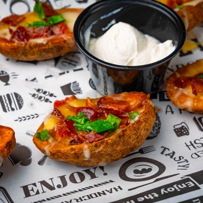 Loaded potato skins served with a dipping sauce.