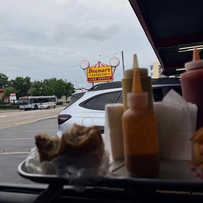 Tray of food hanging from a car's window in our curb service area.  Doumar's sign in the background..