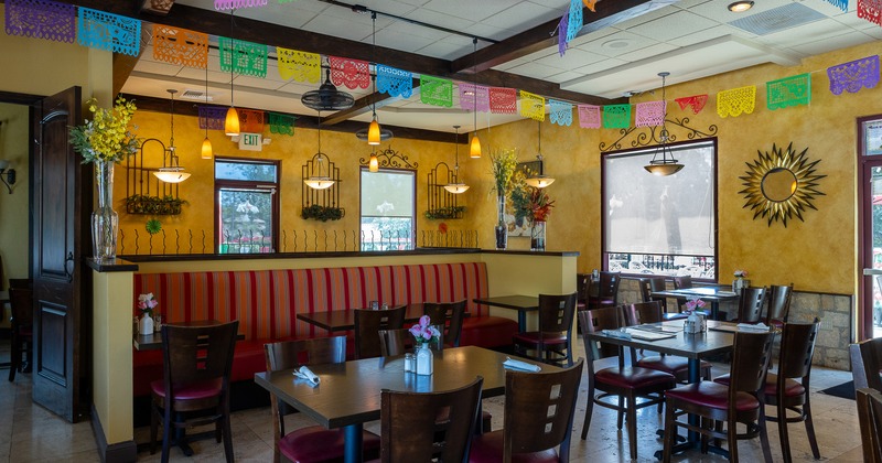 Cozy Mexican style interior dining area decorated with hanging paper ornaments