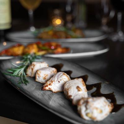 Grilled chicken morsels with a rosemary sprig.