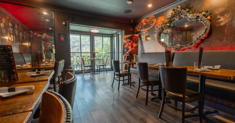 Interior, second floor seating area, wooden tables with banquette benches, terrace