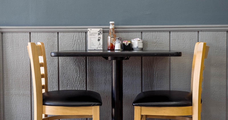 Small dining table with two wooden chairs