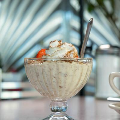 Rice pudding topped with whipped cream and sliced strawberries.