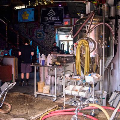 Production area of a craft brewery, featuring stainless steel brewing equipment.