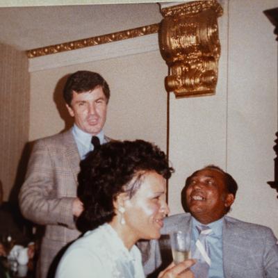 A vintage photo of three people in formal attire within a restaurant setting