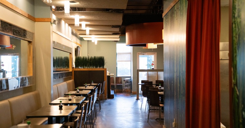 Interior, dining area, long banquette bench with tables and chairs, large mirrors