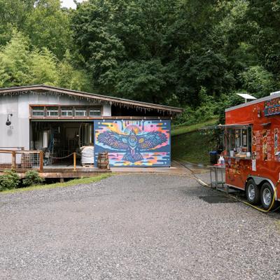 Restaurant buildings beside a colorful food truck.