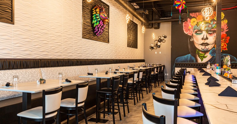 Interior, seating and tables by a wall with artwork decorations