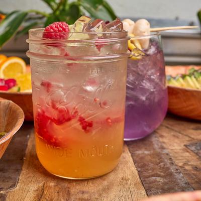 Colorful cocktails with fruit garnishes on a table.