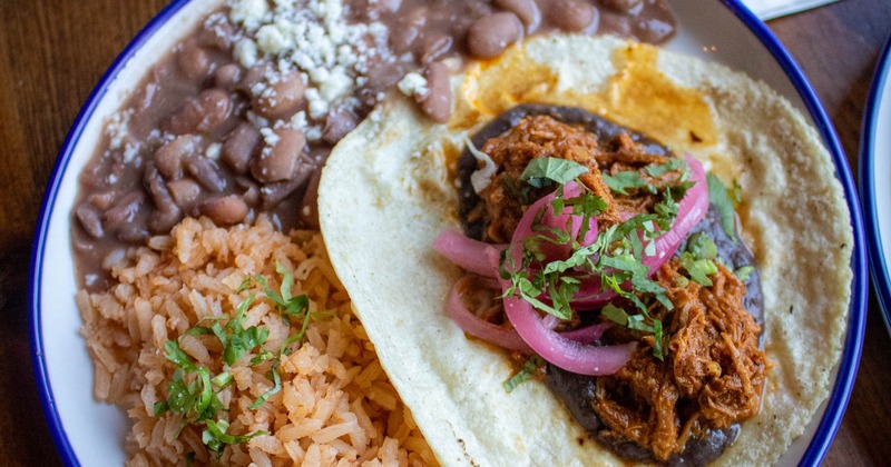 Single taco with sides of rice and beans