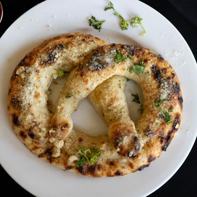 Stuffed Pizza Pretzel on a round white plate, overhead view.