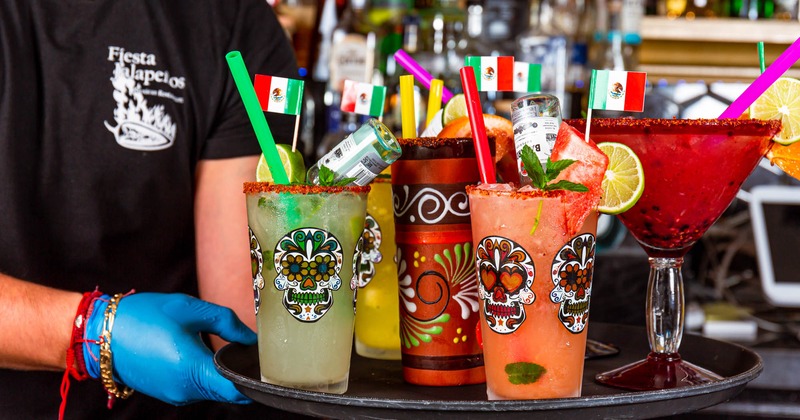 Hands holding a tray with various drinks
