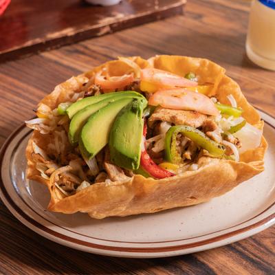 Chicken Fajita salad, with mixed greens, bell peppers, onion, avocado, tomato, and cheese.