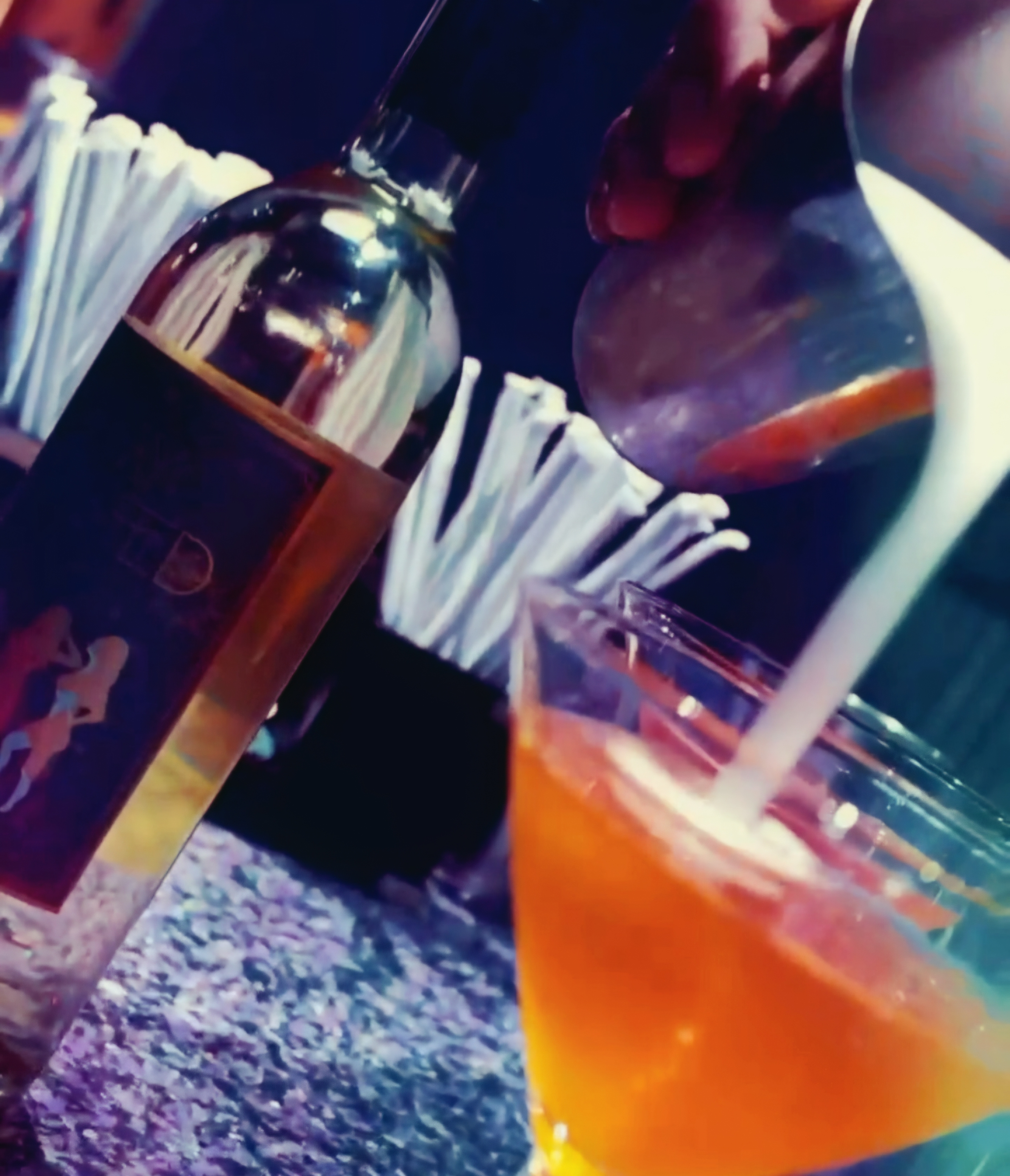 Bartender pouring a cocktail.