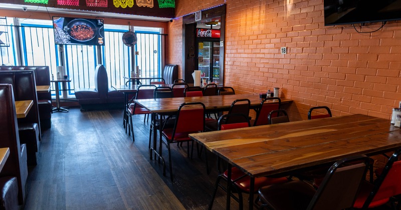 Interior of a casual restaurant with wooden tables, cushioned chairs