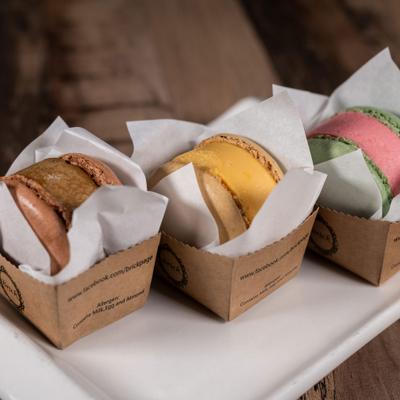 Macaron ice cream served in individual cardboard containers.