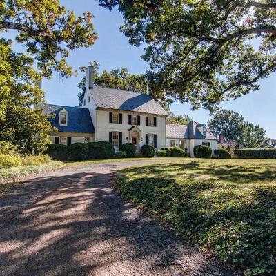White country house with a curved gravel driveway.