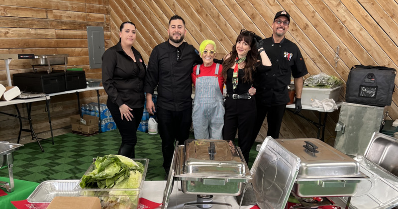 Bonito Michoacan staff stand, with chafing dishes on a table in front, inside a wooden-paneled room