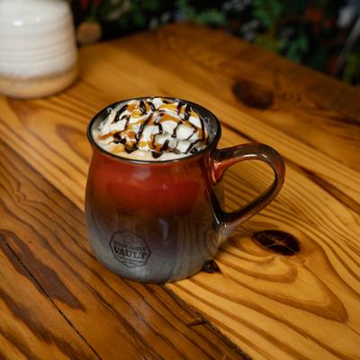 Turtle Mocha served in a ceramic mug on a wooden table.