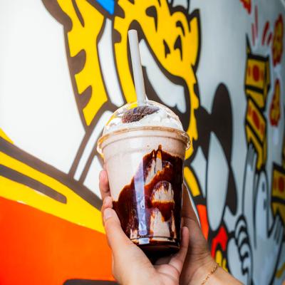 Cup with Oreo Milkshake held in hands.