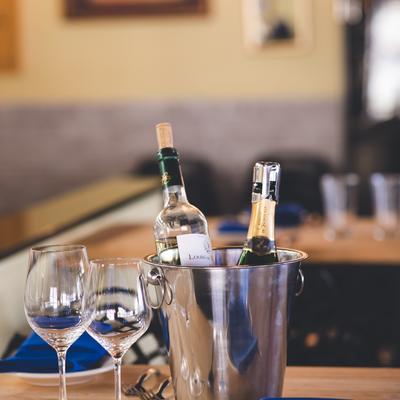 A table set with two elegant wine glasses beside a chilled basket of wine.