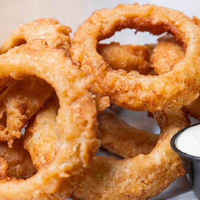 Onion rings served with a dipping sauce, close-up.
