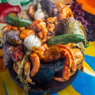 Seafood Molcajete placed on a colorful tablecloth.