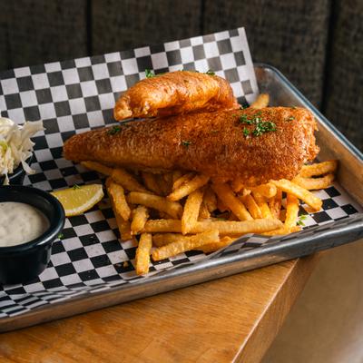 Fish and chips served with coleslaw, dipping sauce and a lemon wedge.