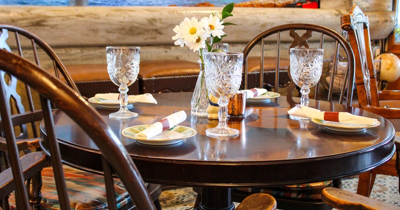 Round dining table set for four guests, close up