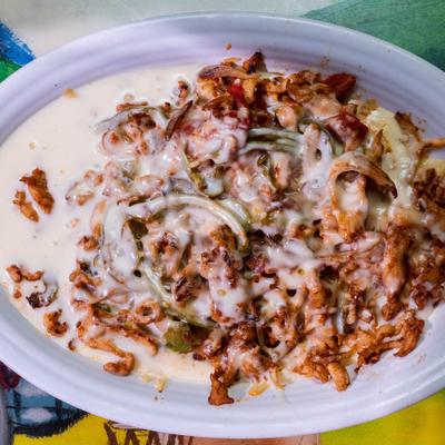 Chicken strips cooked with onions, bell peppers, and tomato, topped with cheese.