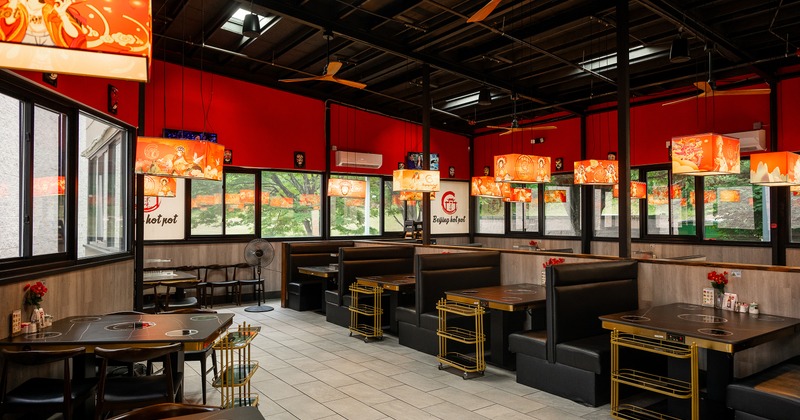 Cozy and spacious interior dining area with tables equipped with built-in hot pot burners