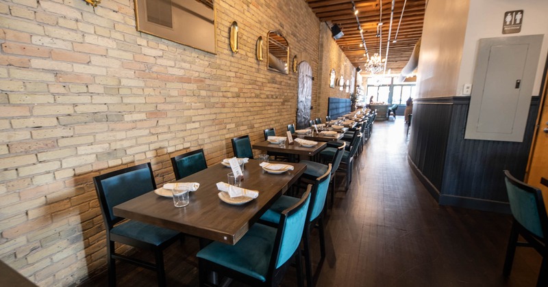 Interior, dining tables lined up and set for guests