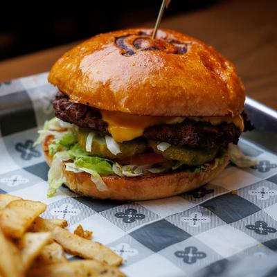 Chute Burger with lettuce, pickles, and cheese, served with fries.