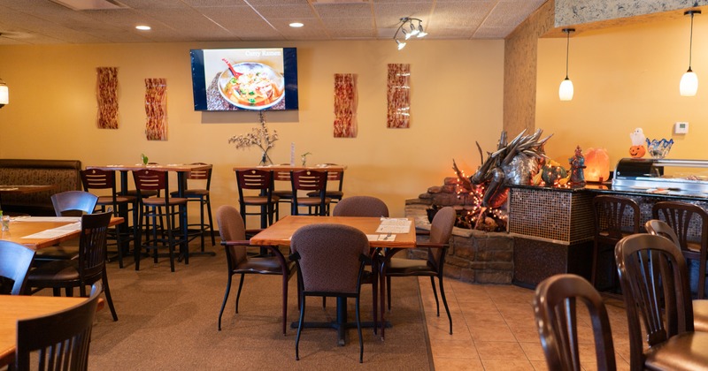 Interior, seating area near a sushi bar, TV and decoration on a wall