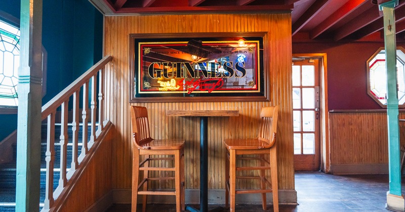 Bar table and 2 chairs, paint above, on the wall