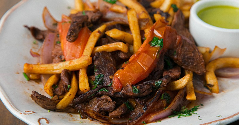 Tender steak strips, with tomatoes, onions, cilantro, soy sauce, and fries