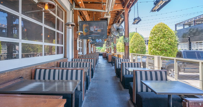 Exterior, seating area with booths, TV screens and hanging fans
