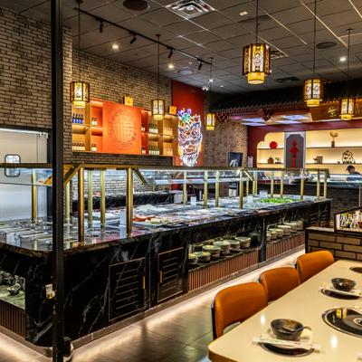 Interior featuring a sleek, dark buffet station with warm, hanging lanterns.