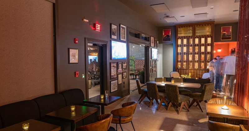 Cozy lounge with wooden tables, brown chairs, candles, framed pictures