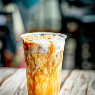 S'mores latte cup sits on a rustic wooden table.
