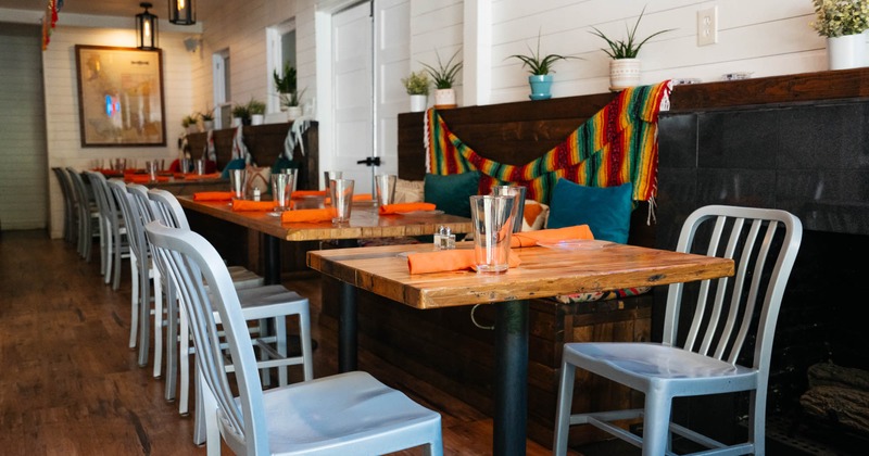 Interior, wooden top tables with chairs, ready for guests, plants in pots as a decoration