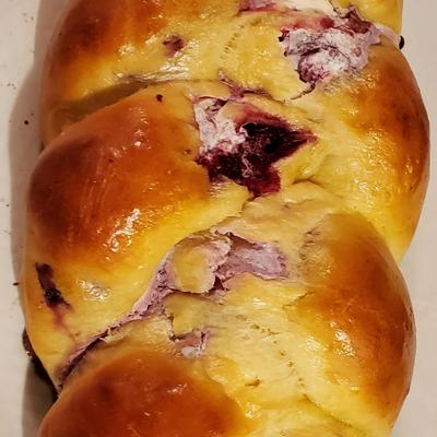 Golden-brown braided bread with filling and glossy crust.