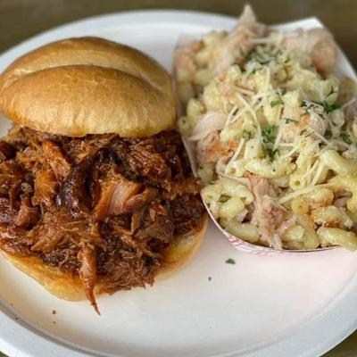 BBQ pulled pork sandwich served with macaroni and cheese.