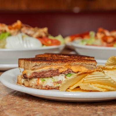 Ruben burger melt sandwich potato chips.