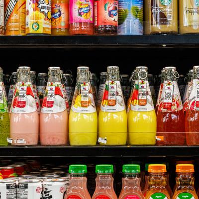 Variety of Asian beverages and tropical fruit juice on the shelves.